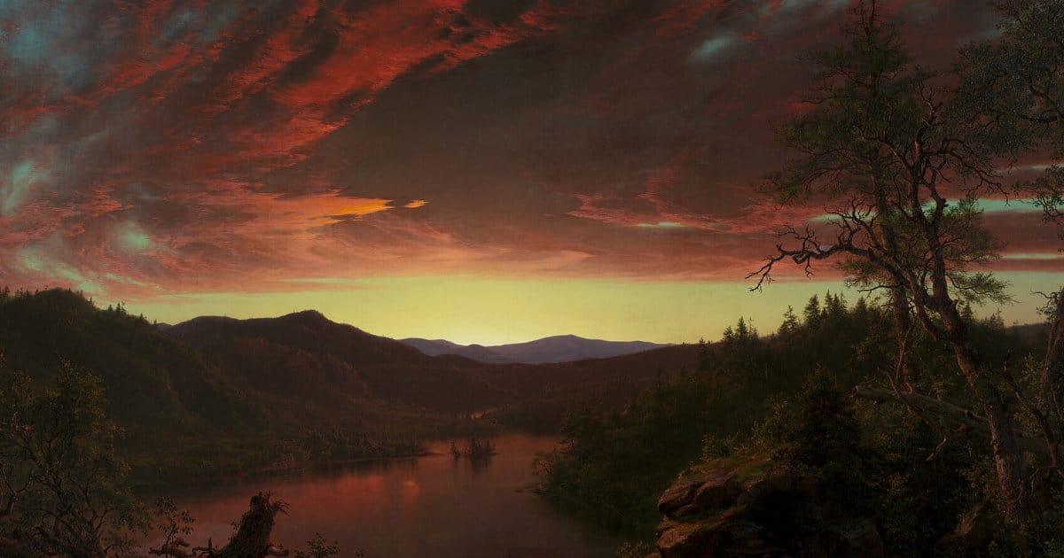 Un tramonto infuocato cala su una foresta montuosa